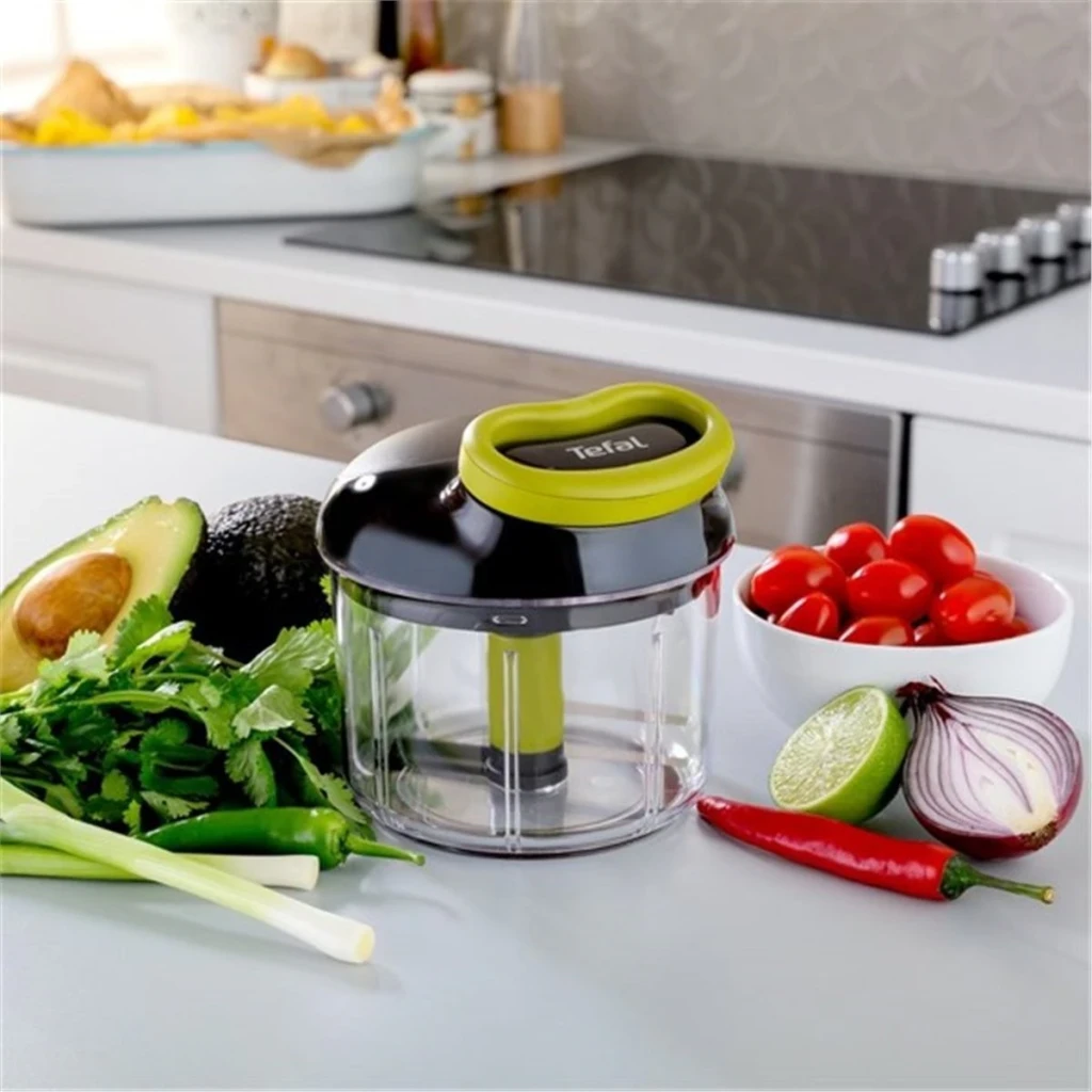 Picadora manual Tefal Ingenio Preto/Verde K13204, em uso: sobre bancada rodeada de abacate, coentros, tomates cherry, cebola