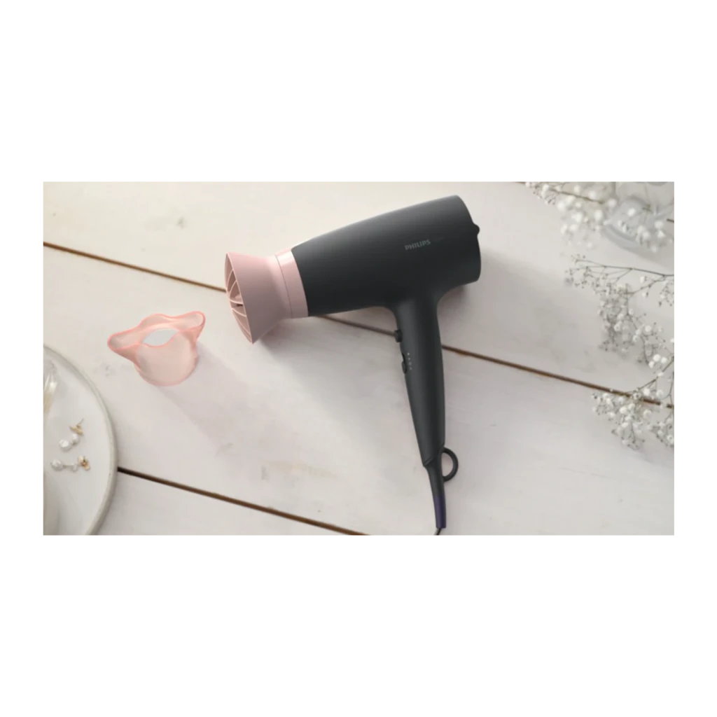 Secador de pelo Philips 3000 Series Iónico 2100W Negro/Rosa BHD350/10, en uso: sobre superficie blanca con difusor rosa