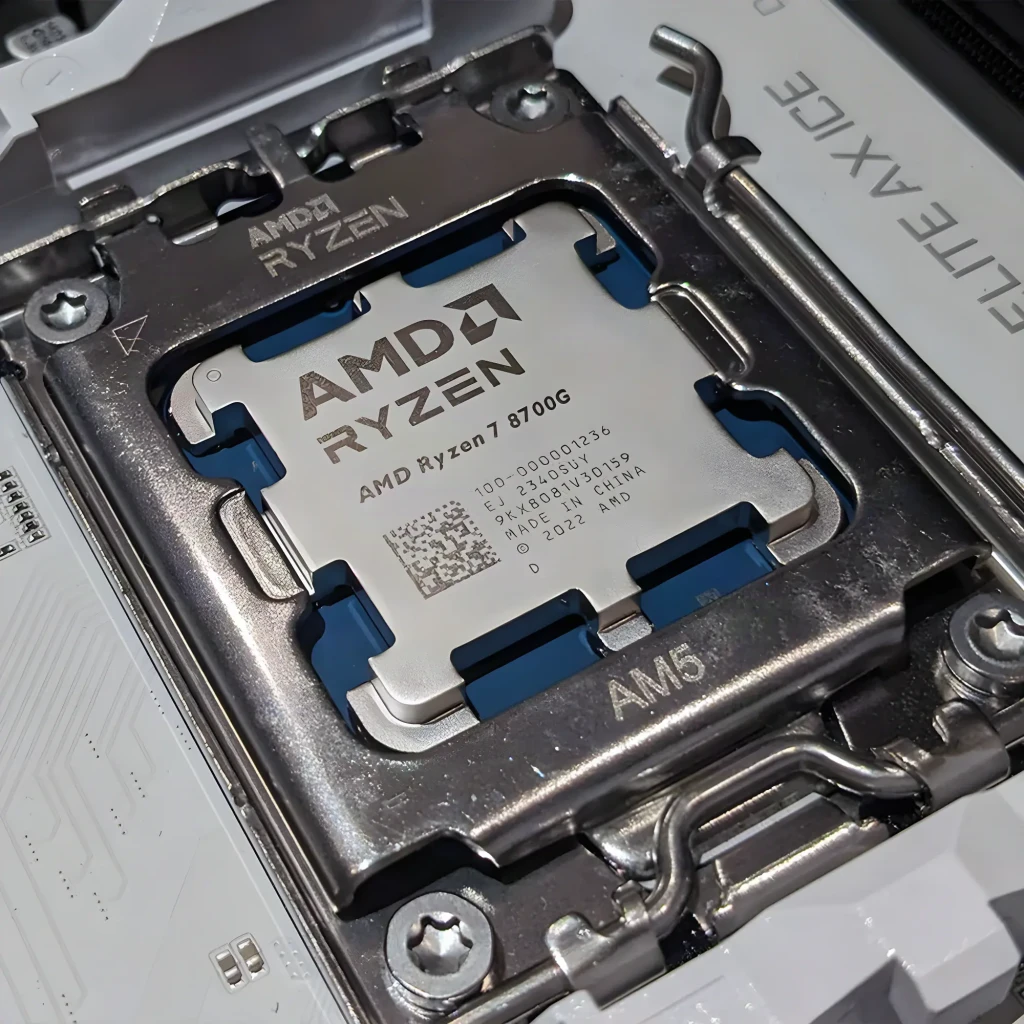 AMD Ryzen 7 8700G 8 Núcleos AM5 Tray, en uso: procesador instalado en socket AM5 de placa base blanca, IHS con grabado