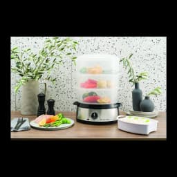 Vaporizador Russell Hobbs Cook@Home 9L 800W Preto 19270-56, em uso: 3 cestos transparentes com legumes e peixe sobre bancada
