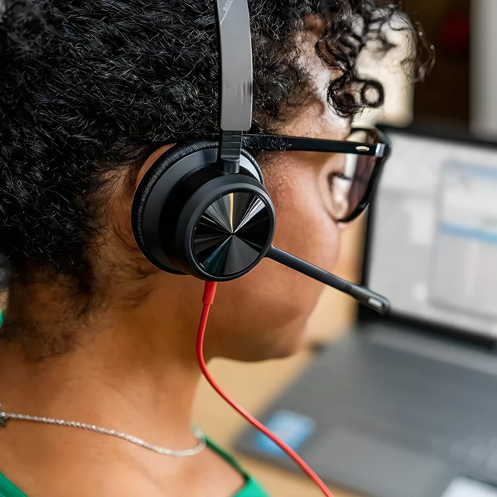 Auriculares Poly Blackwire 8225 USB-C Microsoft Teams Cancelación de Ruido Diadema Negro, en uso: mujer con auricular