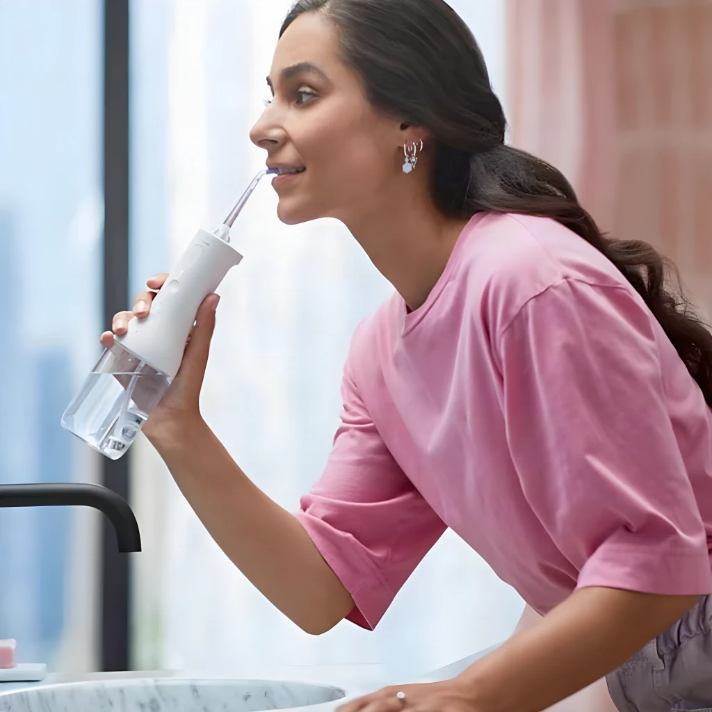 Irrigador oral Philips Sonicare Power Flosser 3000 Sin Cable Blanco HX3826, en uso: mujer inclinada sobre lavabo usándolo