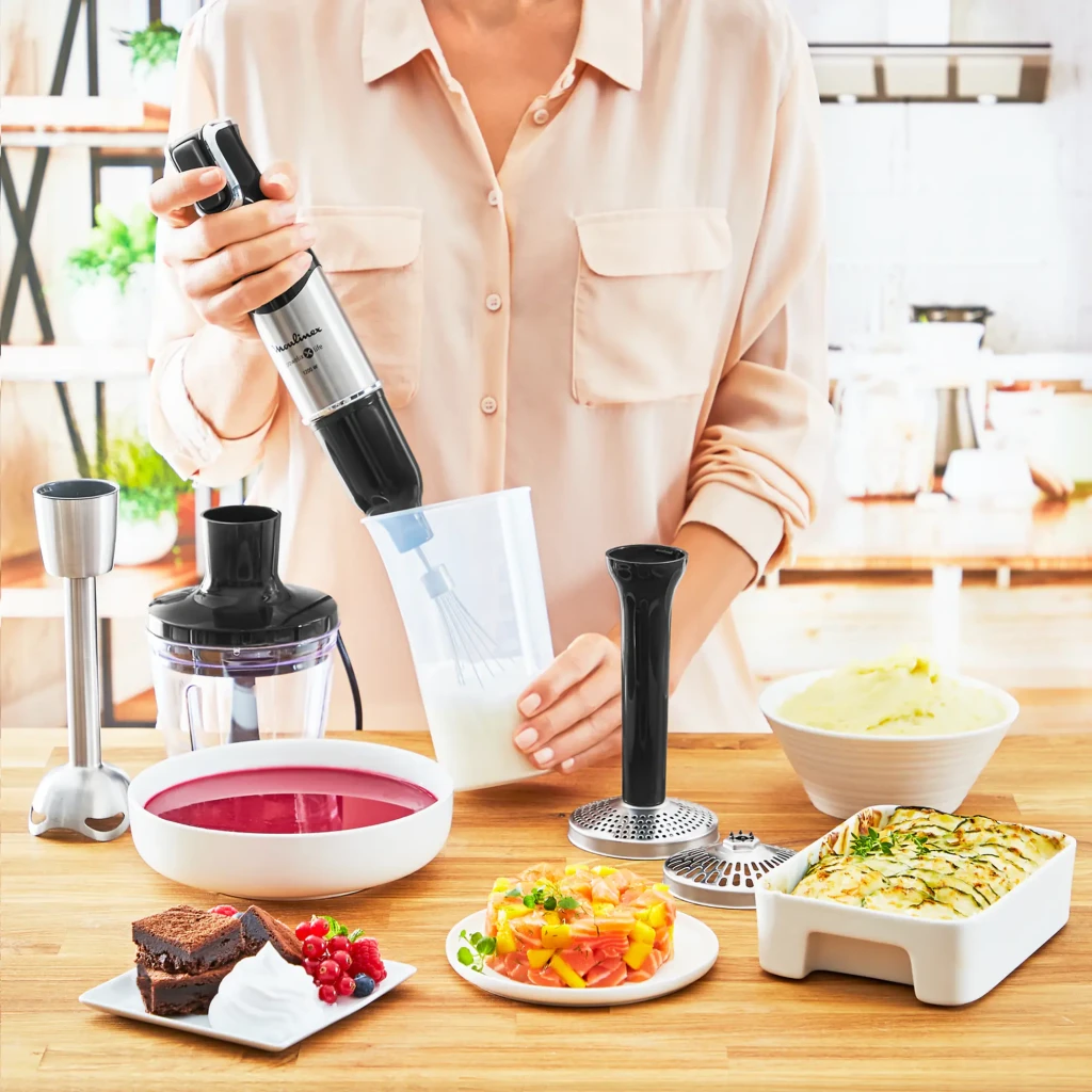 Batidora de mano Moulinex DD95HD 0,8L 1200W Velocidad variable Negro/Acero Inoxidable, en uso: mujer batiendo en vaso