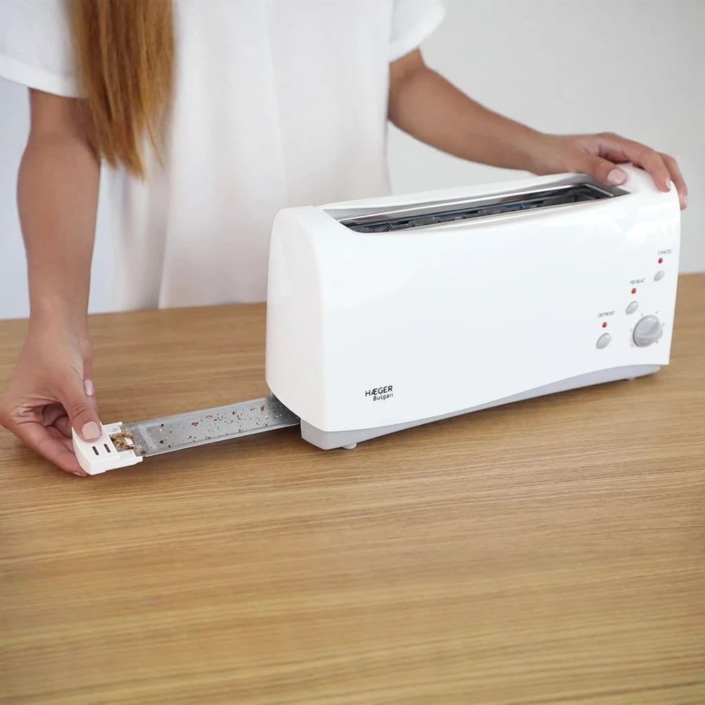 Grille-pain Haeger Bulgari 6 1000W 1 Fente Blanc, en utilisation: femme retire le plateau à miettes sur surface en bois