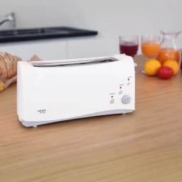 Grille-pain Haeger Bulgari 6 1000W 1 Fente Blanc, en utilisation: vue latérale sur plan de travail en bois avec pain et jus