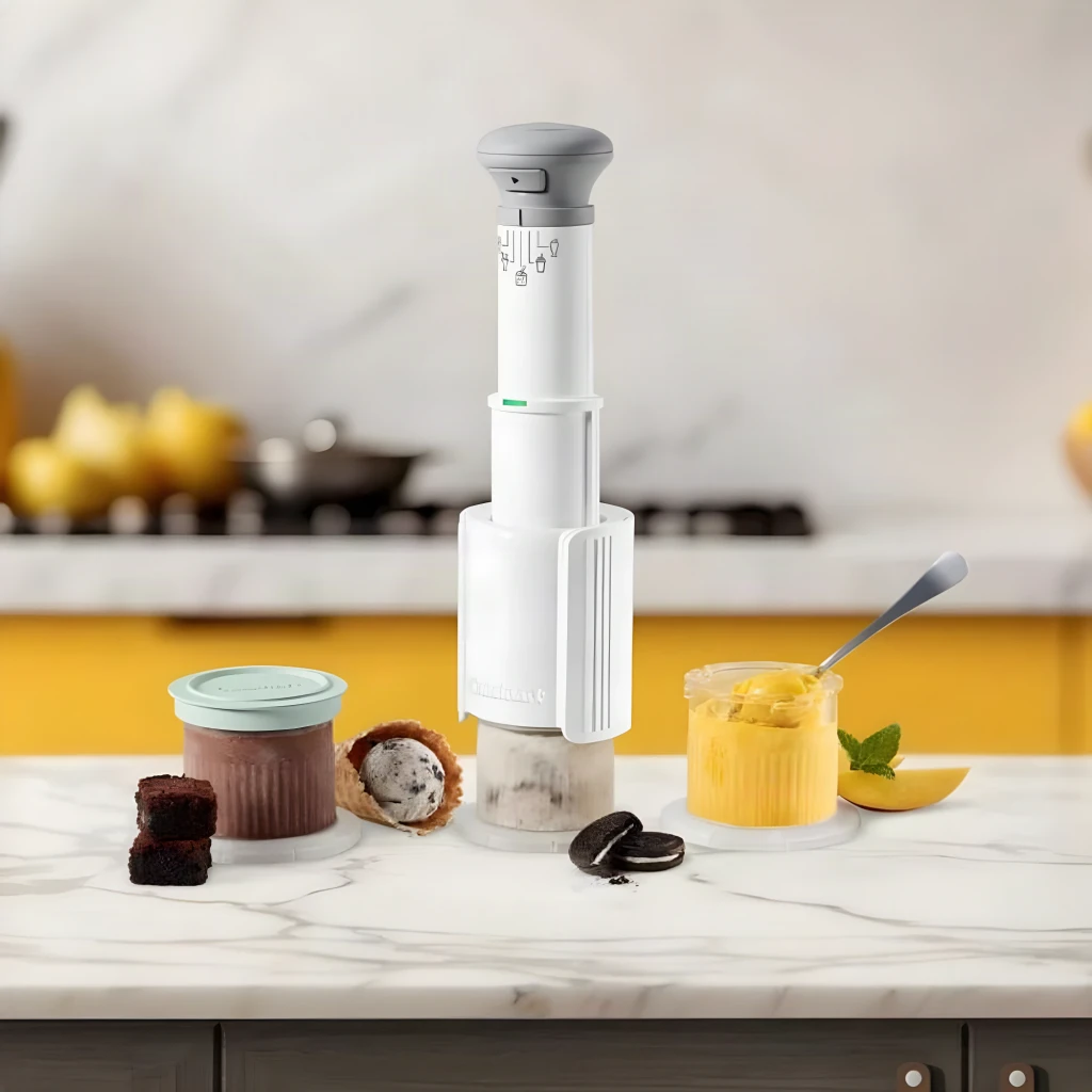 Machine à glace Cuisinart 0,24l Blanc ICEFD10E, en utilisation: sur plan en marbre avec pots de glace chocolat et mangue