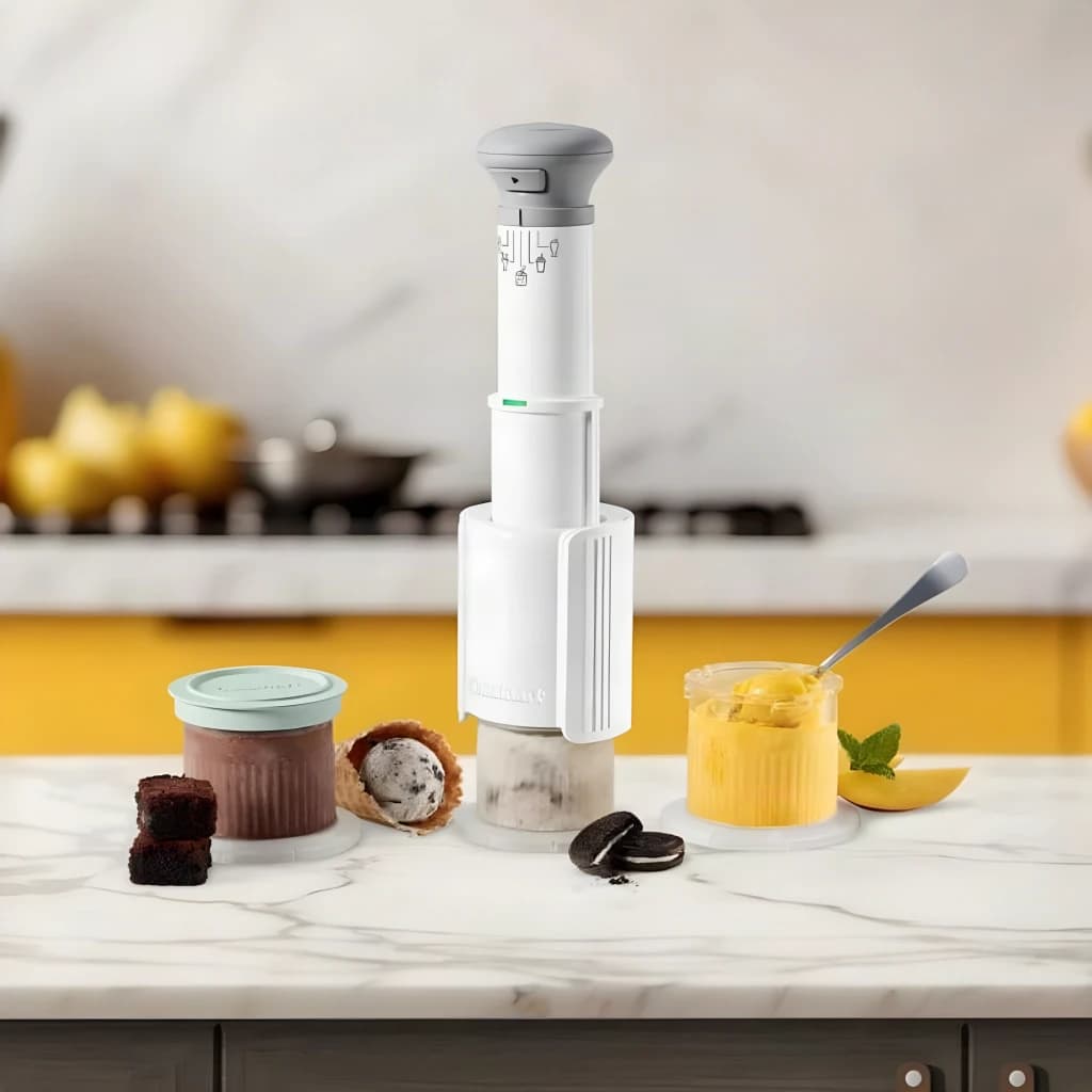 Machine à glace Cuisinart 0,24l Blanc ICEFD10E, en utilisation: sur plan en marbre avec pots de glace chocolat et mangue