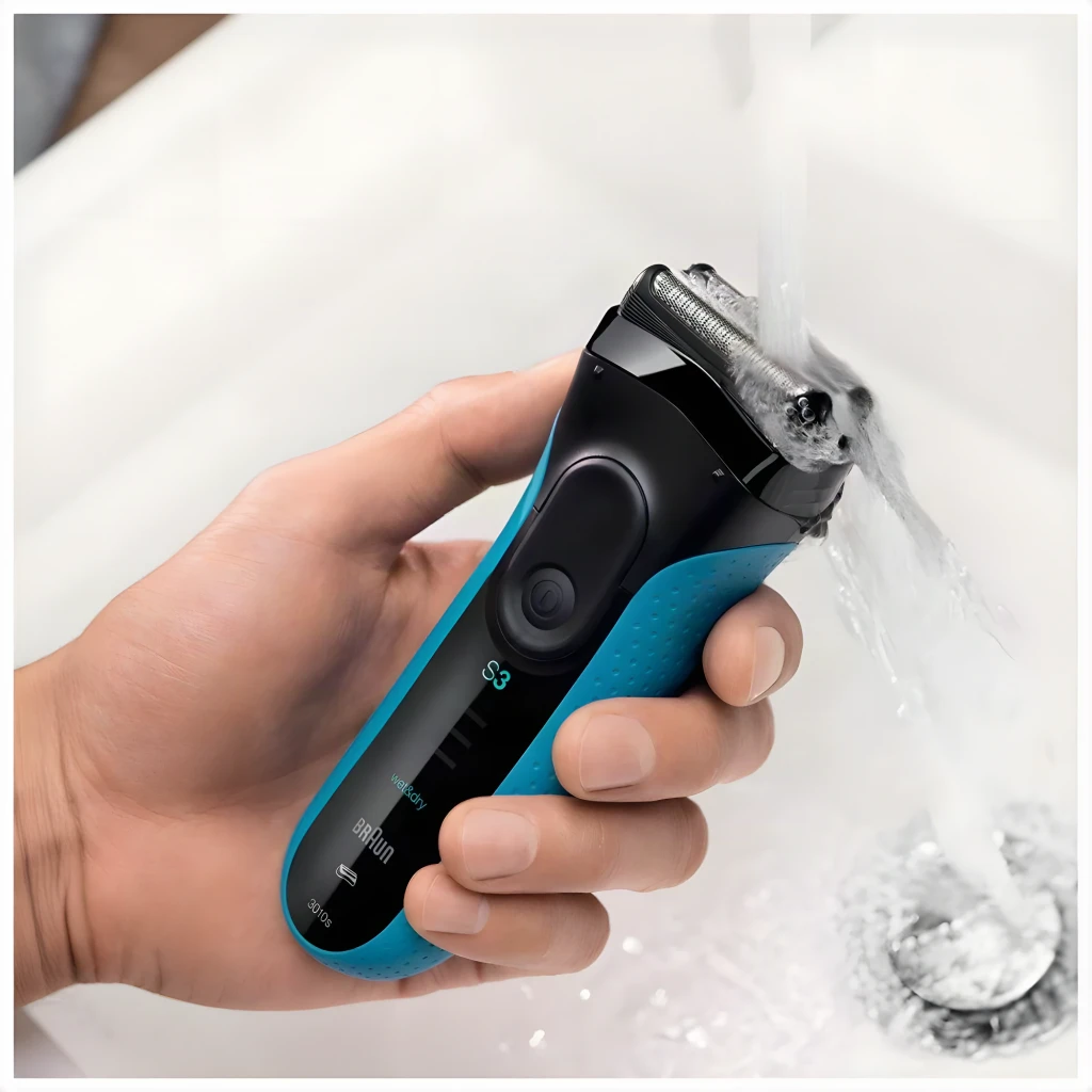 Máquina de Barbear Braun Series 3 3040 Seco e Molhado Lâminas Preto/Azul, em uso: mão a enxaguar a máquina sob água corrente
