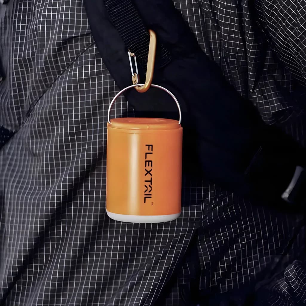 Bomba Portátil Flextail Tiny Pump 2X Laranja USB-C 400lm (3 níveis), em uso: pendurada com mosquetão dourado em mochila