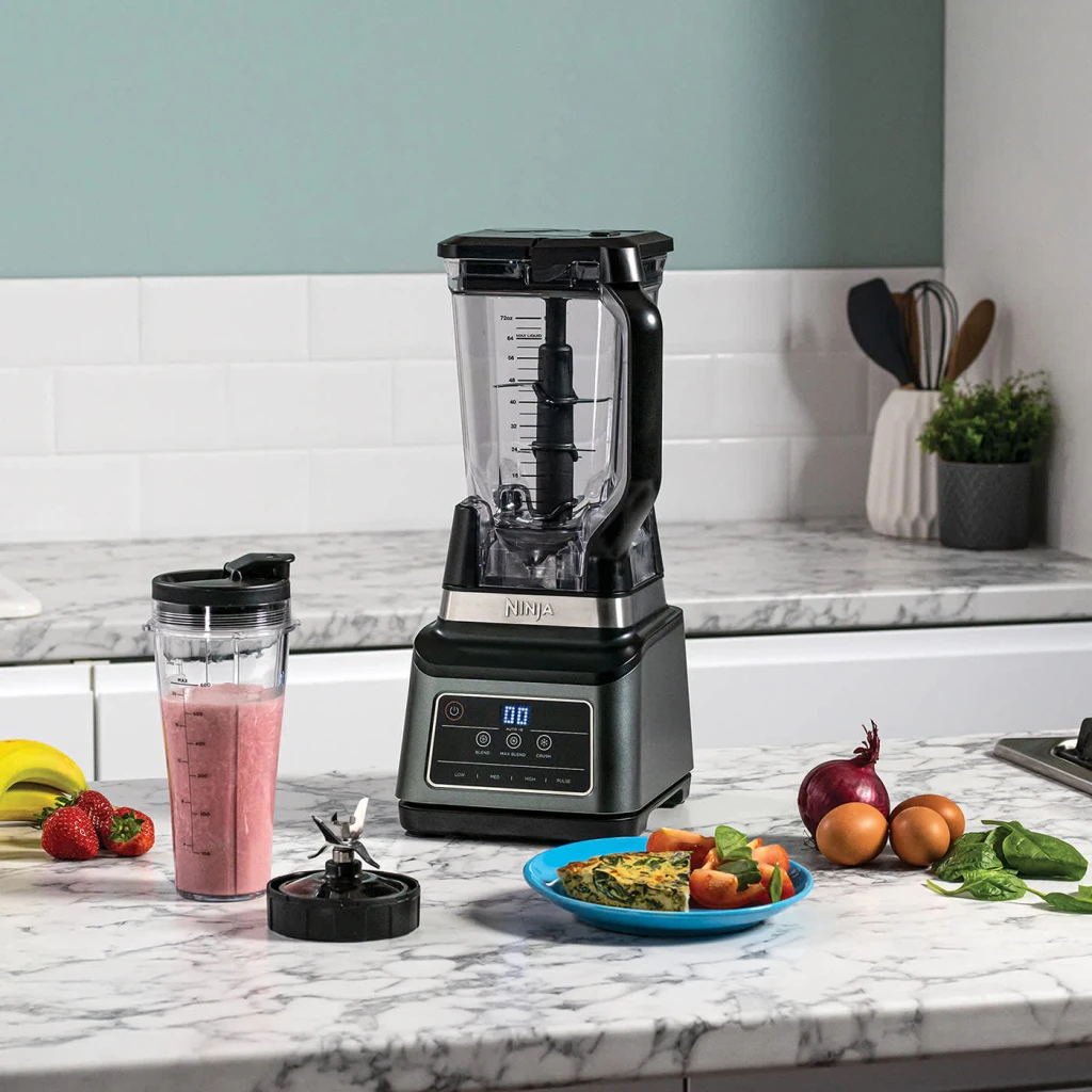 Liquidificador Ninja 2,1L 1200W 3 velocidades Preto BN750EU, em uso: sobre bancada de mármore com smoothie rosa, copo