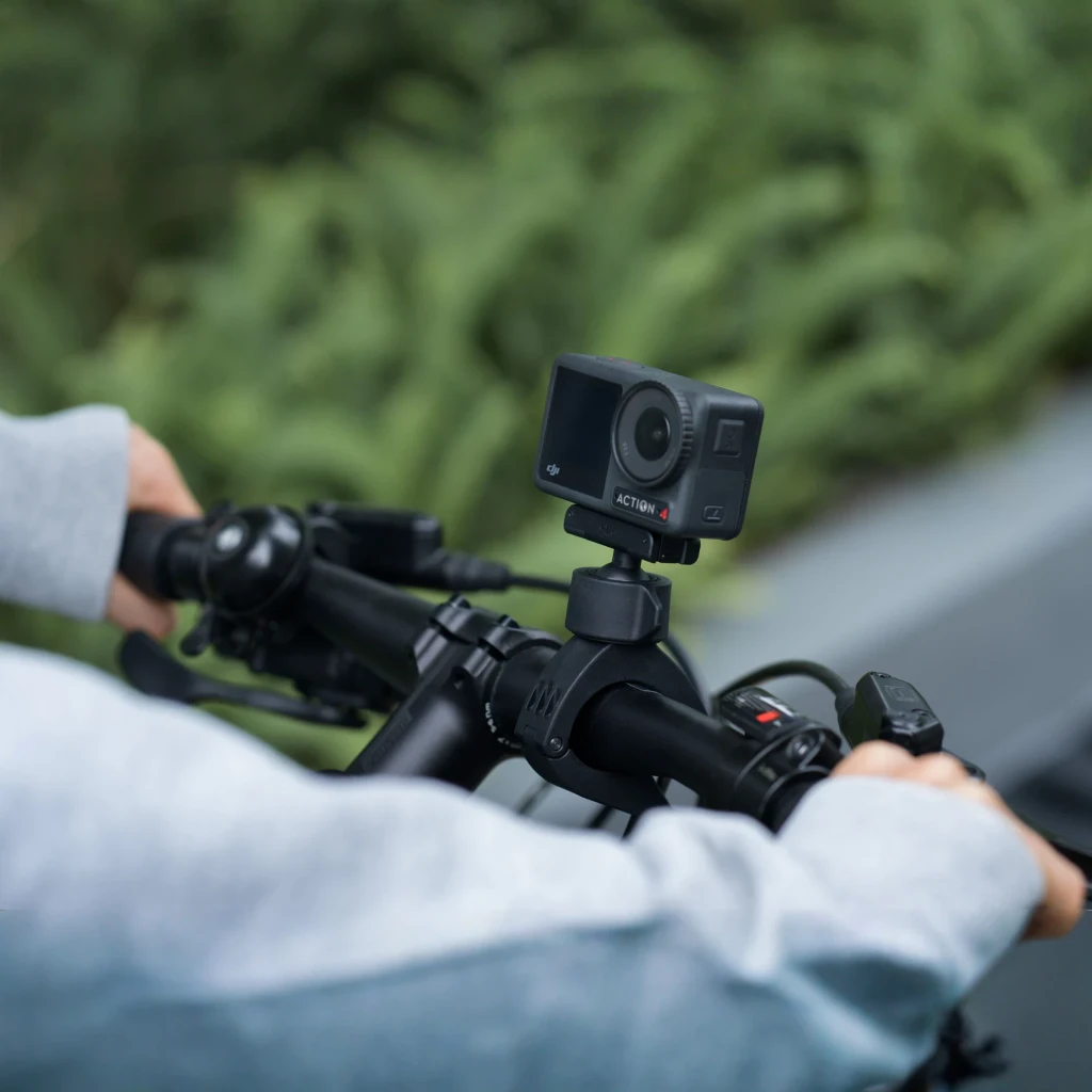 Soporte de manillar DJI Osmo Action Mini Handlebar Mount Negro, en uso: sujeto al manillar de bicicleta con cámara de acción