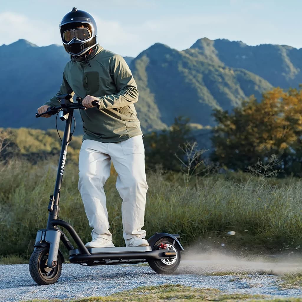 Patinete Eléctrico NAVEE N65i 450W 65km 25km/h 10,5 pulgadas Negro, en uso: rider con casco integral circula por camino