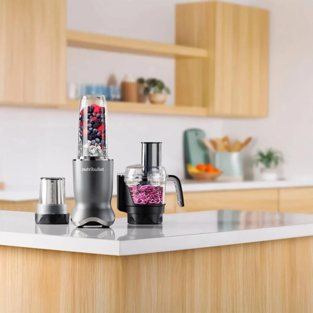 Blender NutriBullet 0,9L 1200W Gris Foncé NB1224DG, en utilisation: bol avec fruits rouges, moulin et robot avec chou rouge