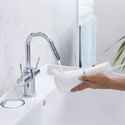 Irrigateur oral Panasonic EW-DJ86 Sans Fil 5 Niveaux Blanc, en cours d'utilisation: main remplissant le réservoir sous