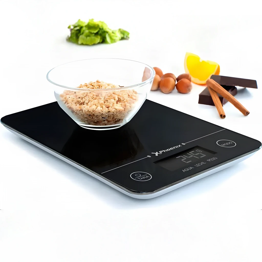 Balance de cuisine Phoenix PHKSCALEB 5 kg Noir, en utilisation: bol avec céréales sur plateau noir, écran LCD affichant