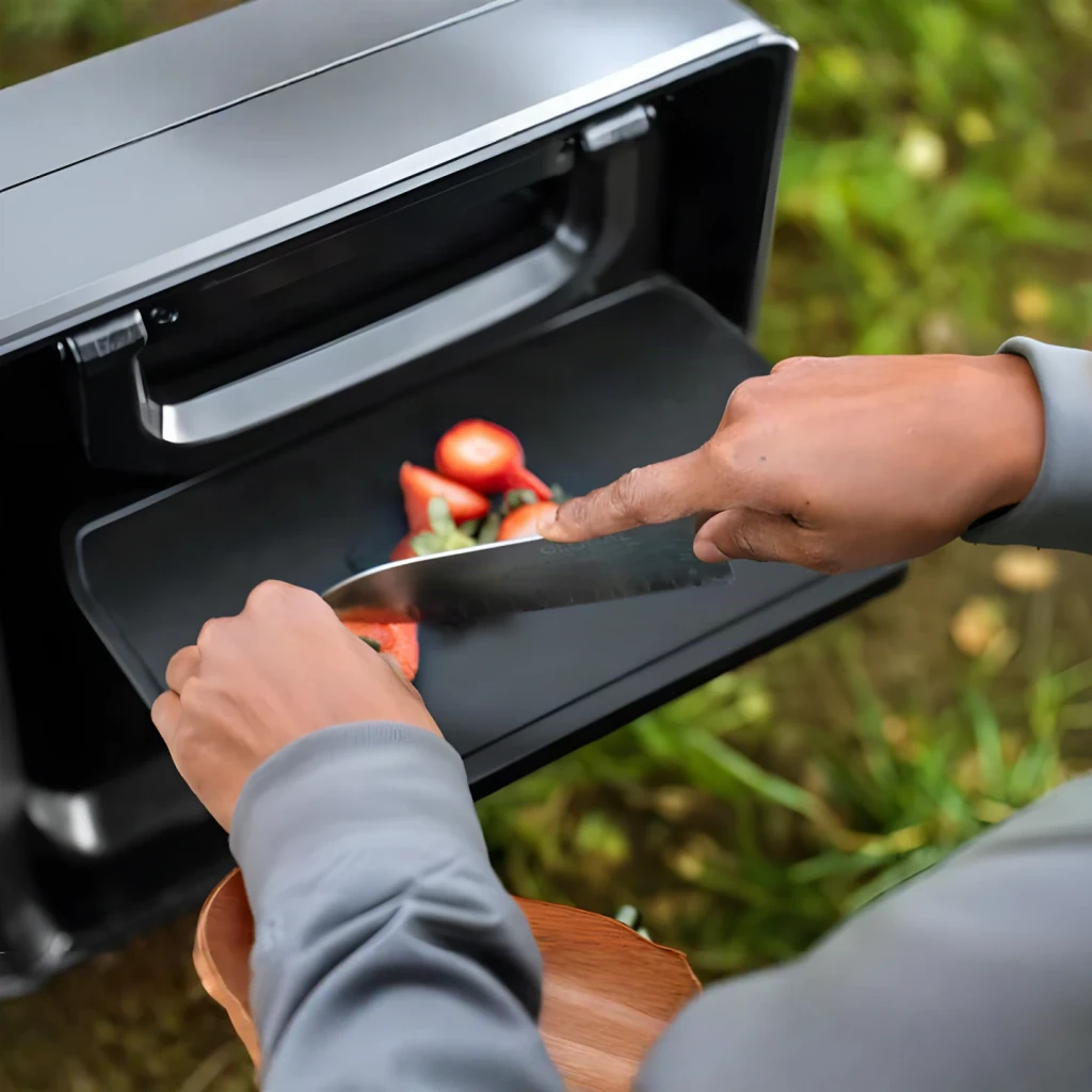 Table accessoire EcoFlow EFA-GLACIERC-TABLE Glacier Classic 45L Noir, en utilisation: personne coupant des fraises