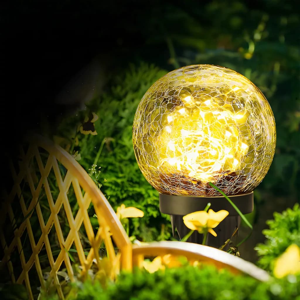 Candeeiro solar Superfire Preto FF16-A, em uso: esfera de vidro craquelado iluminada com luzes quentes entre plantas