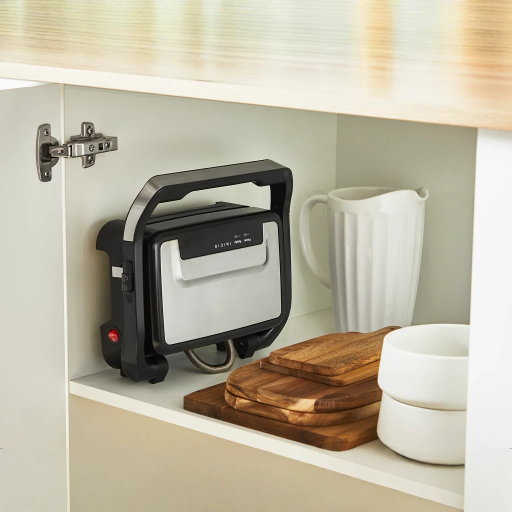 Parrilla eléctrica Moulinex Inicio Compact 1000W 2 personas Negro GI270D, en uso: guardada vertical en armario de cocina