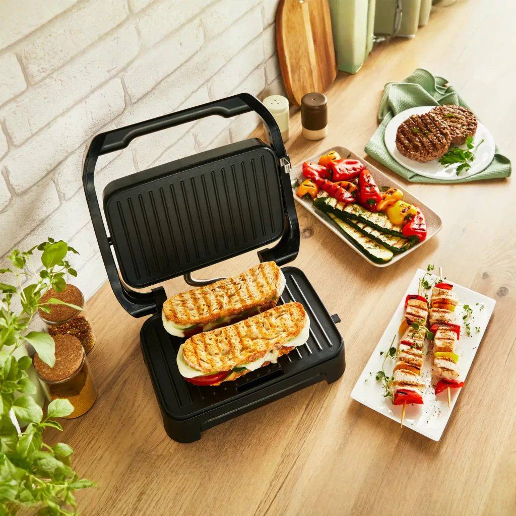 Parrilla eléctrica Moulinex Inicio Compact 1000W 2 personas Negro GI270D, en uso: sandwiches a la plancha entre las placas
