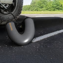 Bomba Elétrica Flextail Evo SUP Pump Pro Cinzento, em uso: a inflar pneu de veículo no asfalto, ecrã digital visível