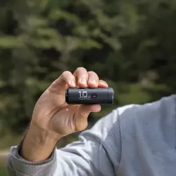 Bomba elétrica Flextail Zero Pump 2 Preto USB-C recarregável, em uso: mão segura o dispositivo cilíndrico mostrando logo