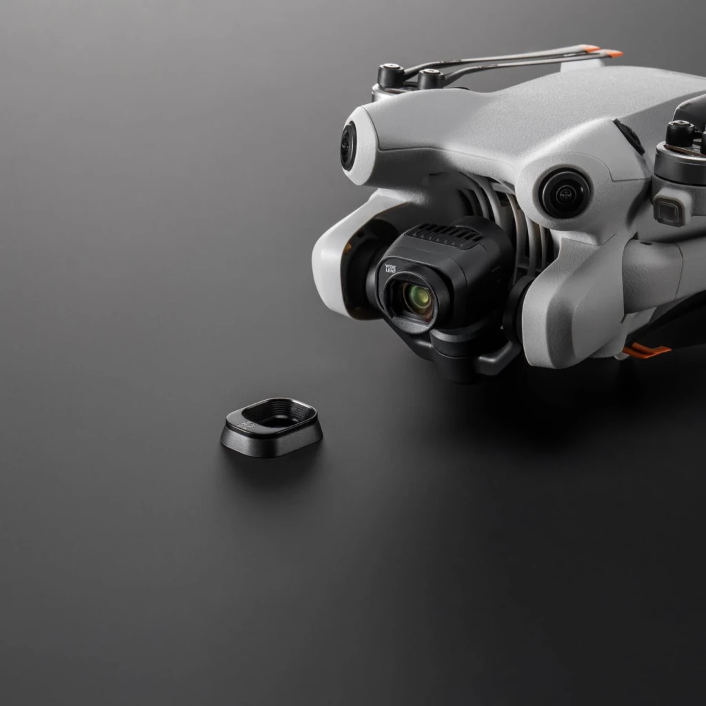 Lente DJI Objetivo Gran Angular Mini 4 Pro Negro, en uso: objetivo montado en dron y tapa negra separada sobre superficie