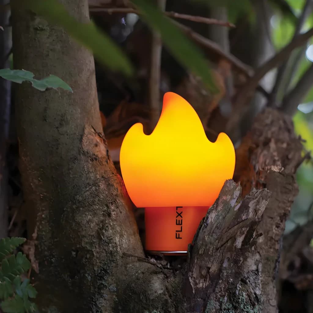 Ecrã difusor Flextail Flame para Tiny Pump 2X Laranja em uso: luz chama acesa entre ramos de árvore no exterior