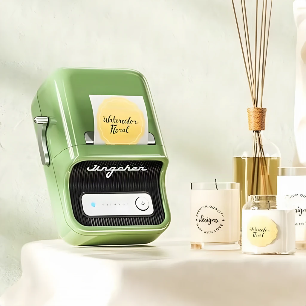 Impresora de etiquetas Niimbot B21 Pro Verde, en uso: imprimiendo etiqueta redonda junto a velas y difusor
