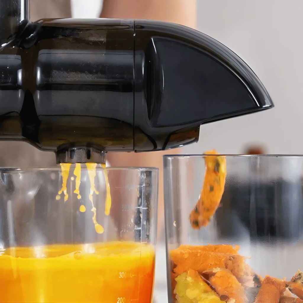 Extractor de zumos AMZCHEF 150W Prensado en frío 7 etapas Negro ZM1501-BK-SM, en uso: zumo de naranja cayendo en vaso