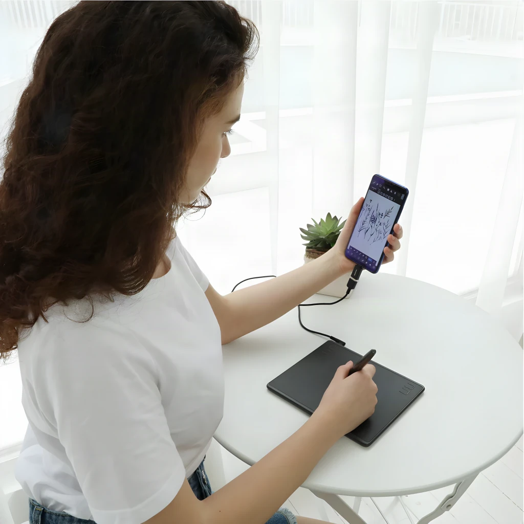Tableta gráfica Huion HS64 Negro 6,3 pulgadas 5080 LPI 8192 niveles de presión, en uso: mujer dibuja con lápiz conectada