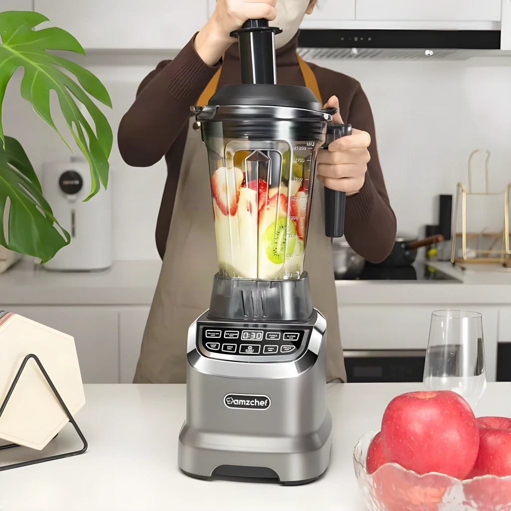 Batidora de vaso Amzchef 1,85L 1800W 26000 RPM Gris ZM5003-GA, en uso: persona coloca tapa con frutas dentro del vaso