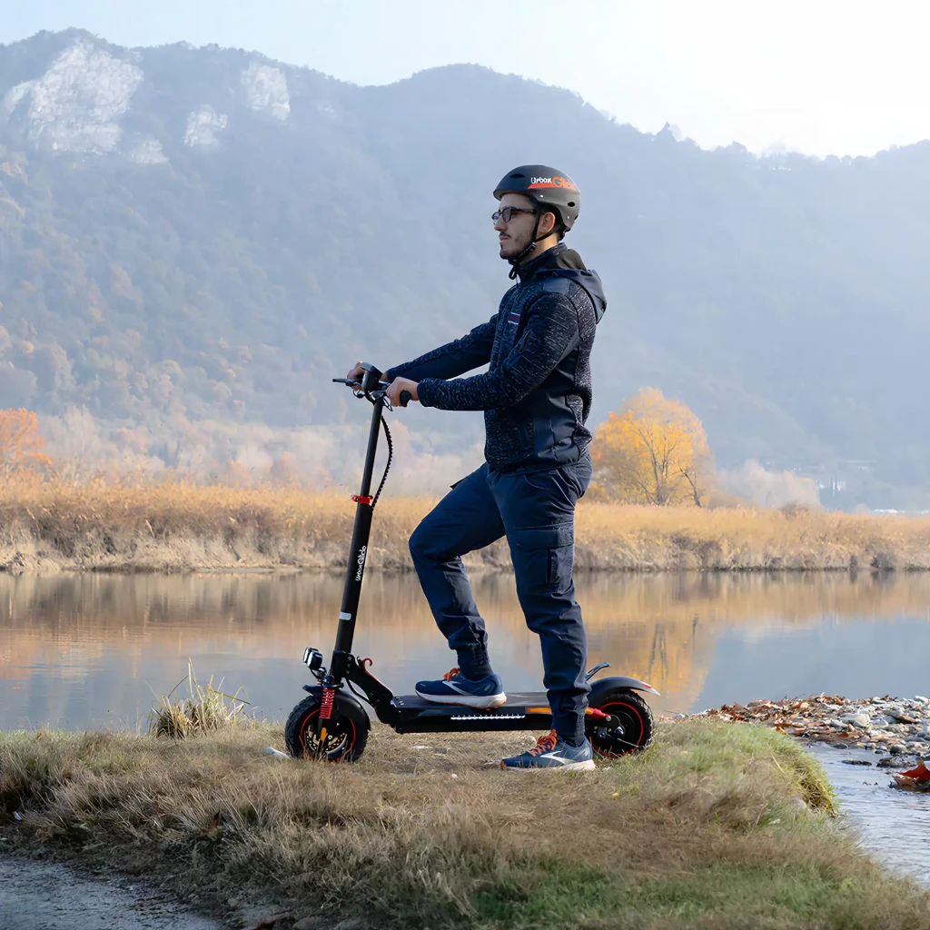 Patinete Eléctrico Urbanglide E-Cross Pro Lite 2 500W 40km 25km/h 10 pulgadas Negro, en uso: rider con casco junto a río