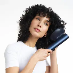 Difusor para secador BaByliss Air Power Azul ACAS6550DIF, en uso: mujer con rizos usando el difusor azul sobre su cabello