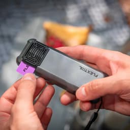 Repelente de mosquitos Flextail Max Repel S IP65 9600mAh Powerbank Cinzento, em uso: mãos a inserir pastilha repelente roxa