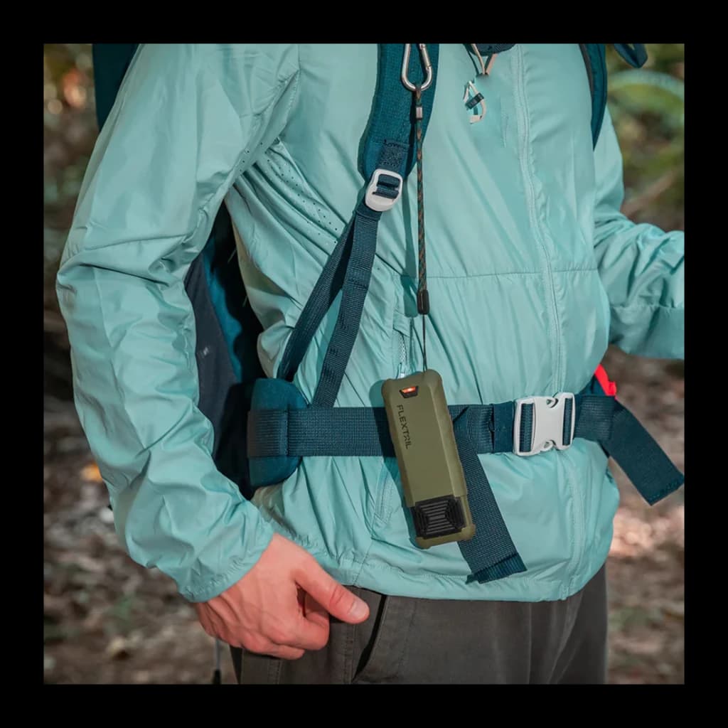 Repelente de mosquitos Flextail Max Repel S Verde, em uso: pendurado no peito de um caminhante com mochila em ambiente