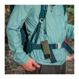 Repelente de mosquitos Flextail Max Repel S Verde, em uso: pendurado no peito de um caminhante com mochila em ambiente