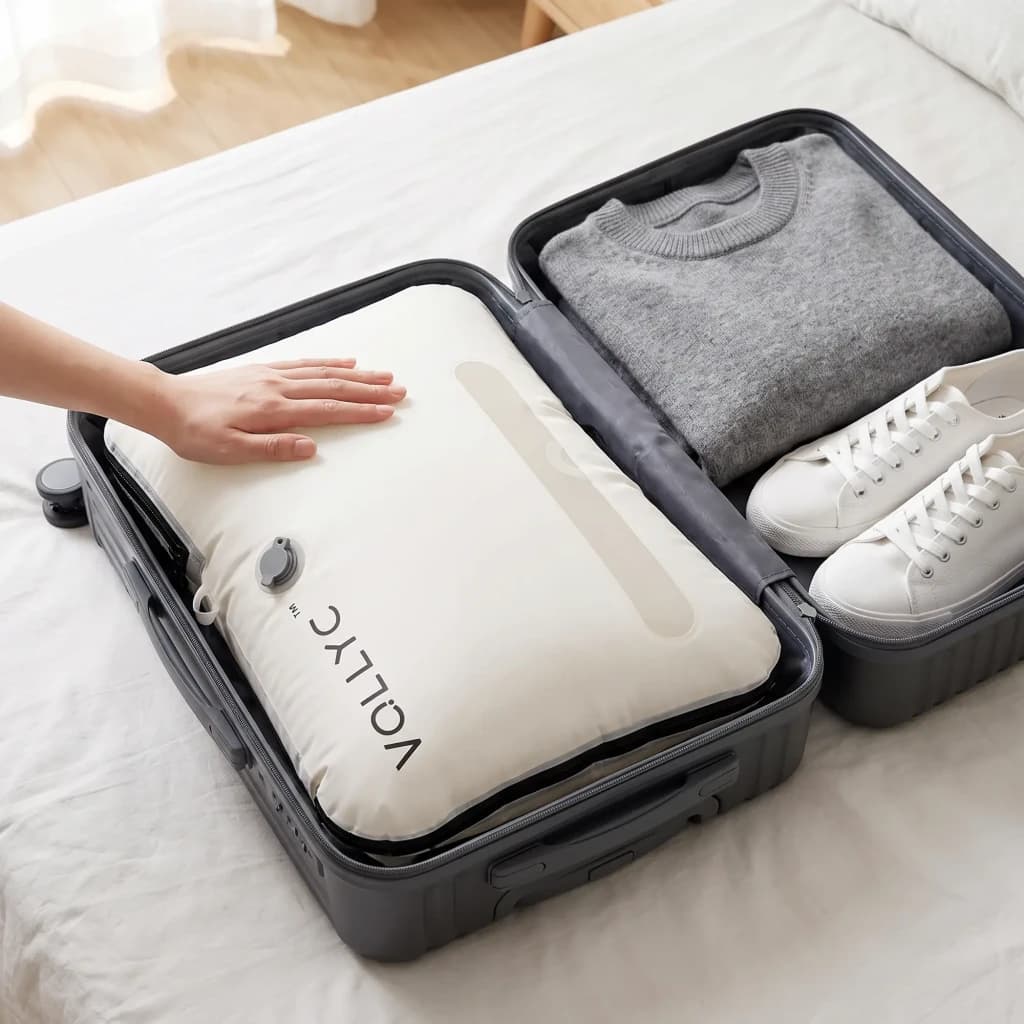Organizador de viaje Flextail EZYPACK Blanco Nylon 70D TPU impermeable 35x11x50cm, en uso: mano presionando la bolsa inflada