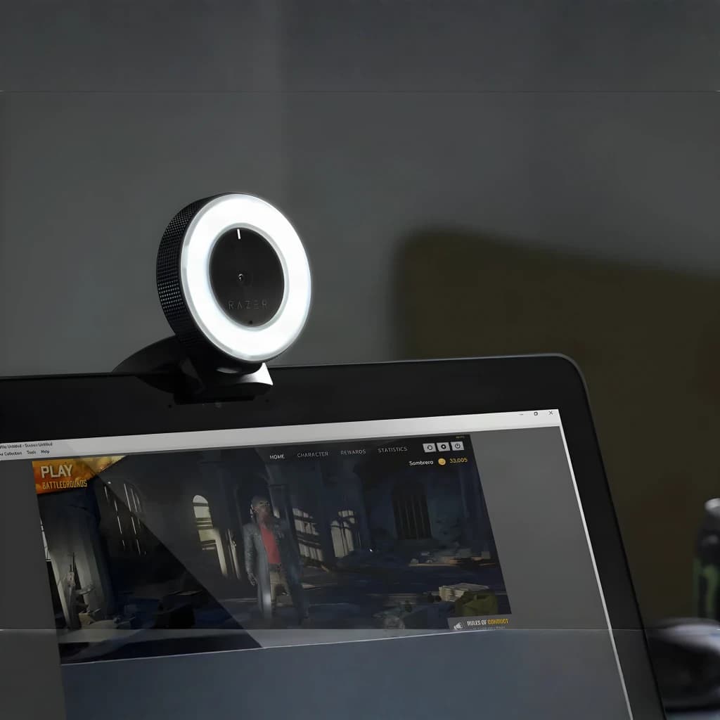 Webcam Razer Kiyo Full HD 60fps Microfone USB Preto em uso: presa ao monitor com ring light aceso e jogo na tela