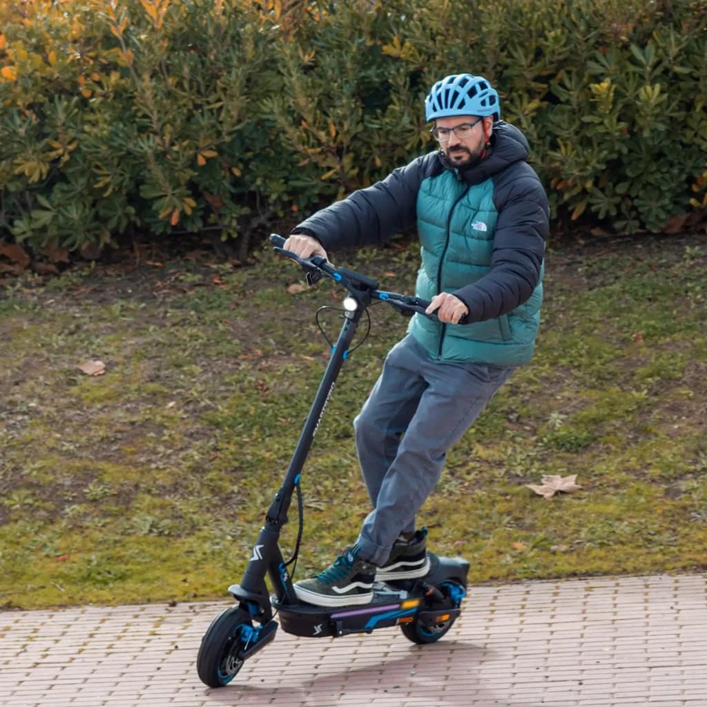 Patinete Eléctrico smartGyro K5 Pro 900W 60km 25km/h 10 pulgadas, en uso: hombre con casco circulando en exterior