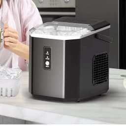 Máquina de gelo Euhomy IM011 1.2L 12 kg/dia Preto, em uso: tampa aberta com gelo, balde cheio e mão segurando copo