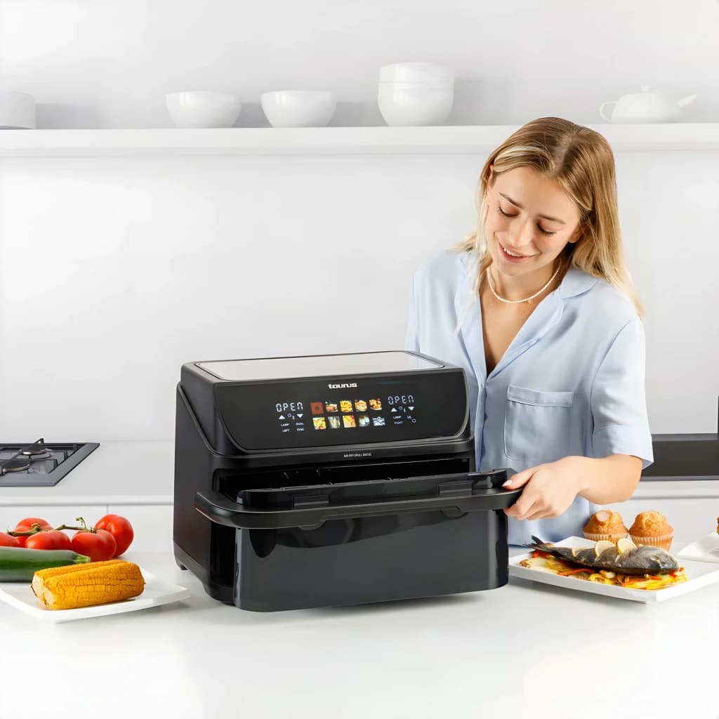 Fritadeira de Ar Taurus Grill 360 XL 10L 2800W 10 programas Preto, uso: mulher abre a gaveta na cozinha com alimentos ao