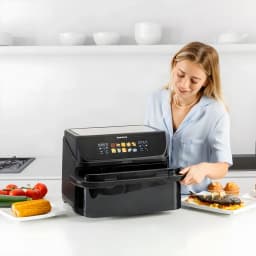 Friteuse à air Taurus Grill 360 XL 10L 2800W 10 programmes Noir, usage: femme ouvrant le tiroir en cuisine avec aliments