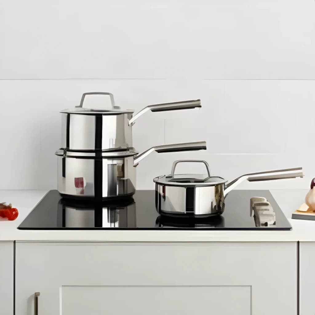 Conjunto de caçarolas Ninja Preto/Prata C63000EU, em cozinha: três caçarolas empilhadas e uma separada em placa de indução