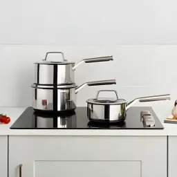 Conjunto de caçarolas Ninja Preto/Prata C63000EU, em cozinha: três caçarolas empilhadas e uma separada em placa de indução