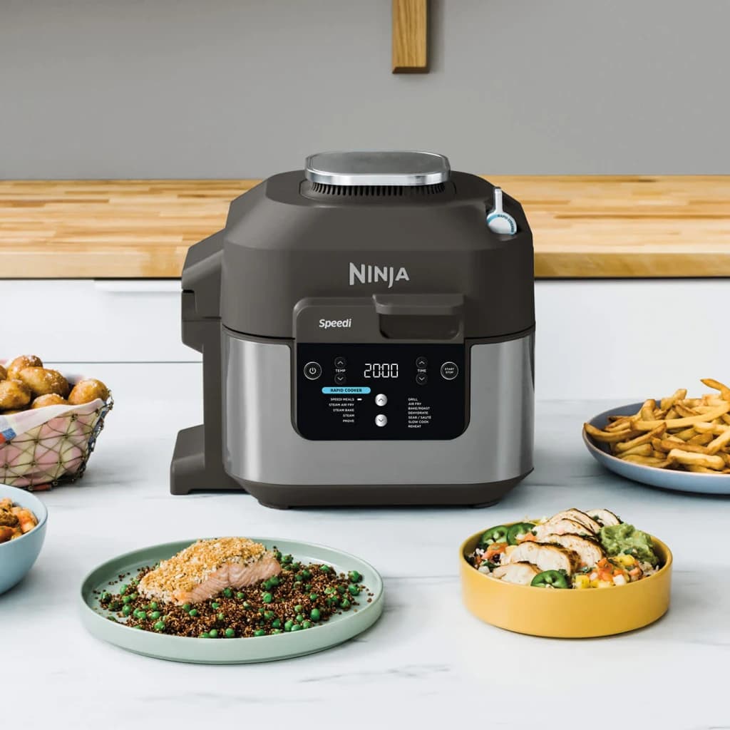 Freidora de Aire Ninja Speedi 5,7L 1760W Negro ON500EU, en uso: sobre encimera rodeada de platos con salmón, quinoa, pollo