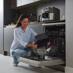 Freidora de Aire Ninja Speedi 5,7L 1760W Negro ON500EU, uso: mujer introduce el cesto negro en el lavavajillas