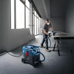 Aspirateur industriel sec/humide Bosch GAS 400 A Professional Bleu Sans Fil 1200W, en utilisation: opérateur avec scie