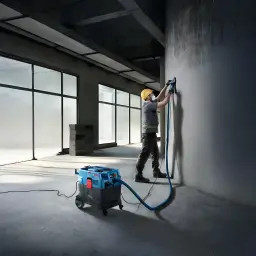 Aspirateur industriel sec/humide Bosch GAS 400 A Professional Bleu Sans Fil 1200W, en utilisation: ouvrier ponçant un mur