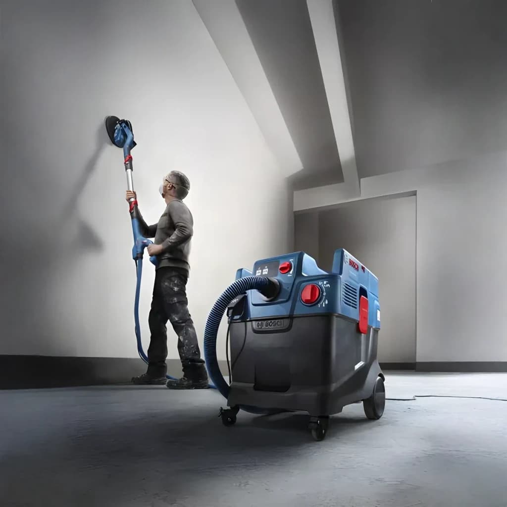 Aspirateur industriel sec/humide Bosch GAS 400 A Professional Bleu Sans Fil 1200W, en utilisation: opérateur ponçant un mur