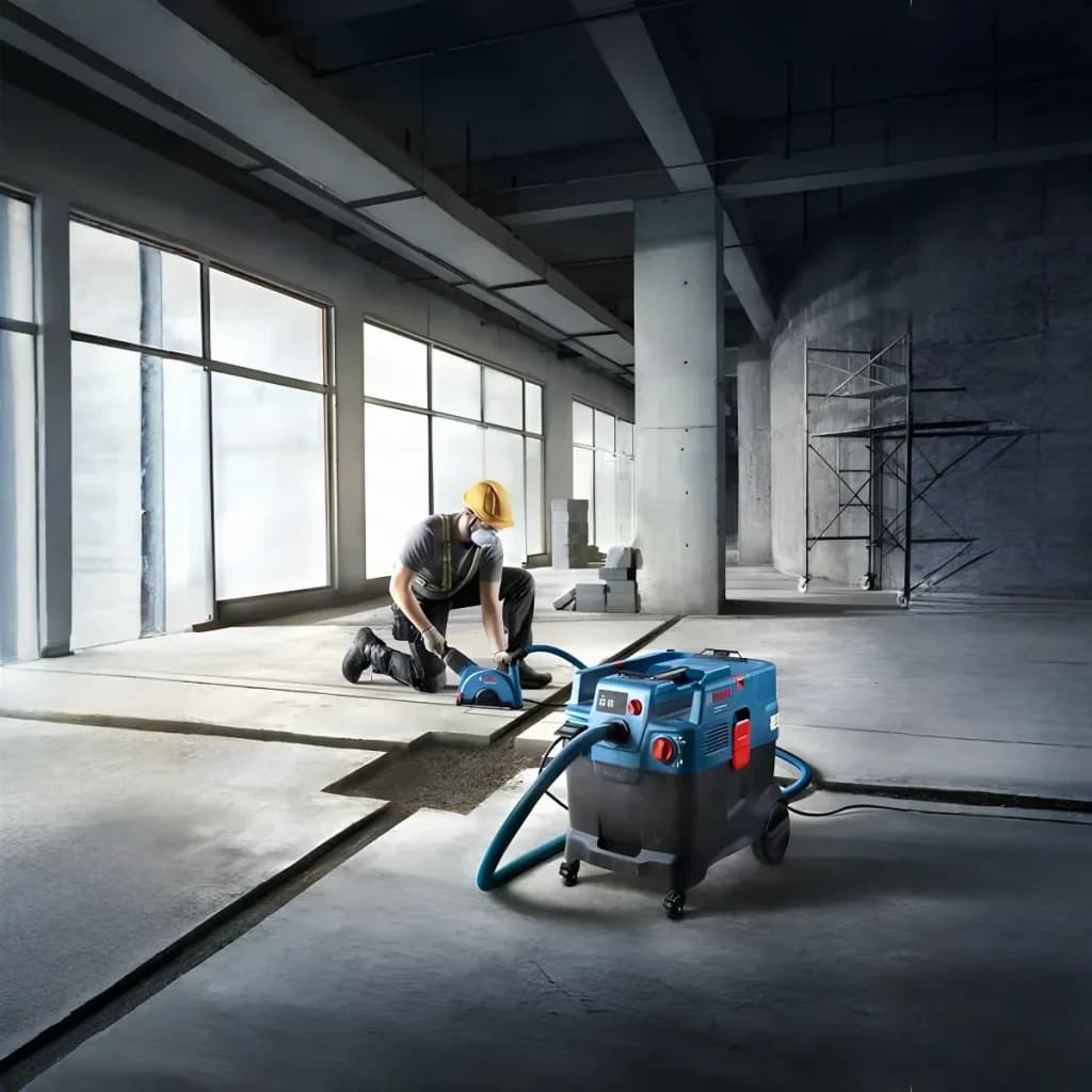 Aspirateur industriel sec/humide Bosch GAS 400 A Professional Bleu Sans Fil 1200W, en utilisation: ouvrier ponçant sol béton